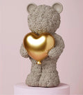 “Grijze teddybeer met glanzend gouden hart uit de Love Is Sweet collectie – romantisch cadeau met liefdevolle uitstraling”